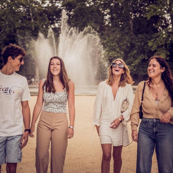 Diverse group of people smiling and walking in a park.